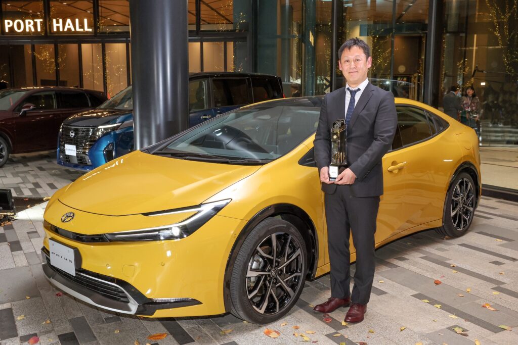 Toyota Prius chief engineer Satoki Oya holds the Japan Car of the Year trophy