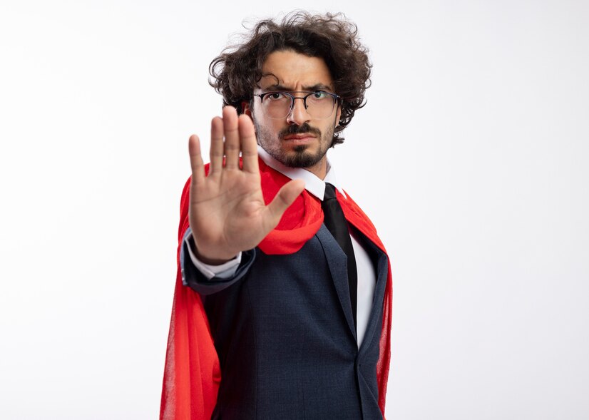 confident young caucasian superhero man optical glasses wearing suit with red cloak gesturing stop hand sign 141793 100093